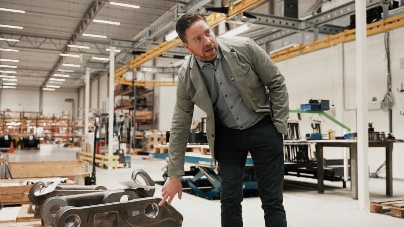 A Steelwrist employee inspecting quick couplers on the factory floor